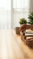 Hands arranging wooden blocks with business icons in staircase shape on desk, symbolizing strategy, growth, and step-by-step planning.