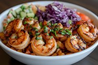 Grilled shrimp bowl with fresh vegetables and purple cabbage slaw for healthy meal prep and restaurant menu photography.