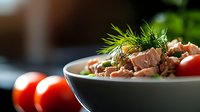 Fresh tuna salad with cherry tomatoes and dill garnish in ceramic bowl, healthy Mediterranean cuisine for restaurant menus and cooking blogs.