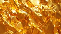 Crumpled gold foil texture with shiny metallic surface creating abstract pattern of light and shadows. Luxury background for premium designs and festive decorations.
