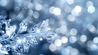 Delicate ice crystal formation with blue tones against blurred bokeh background, creating winter atmosphere for seasonal designs.