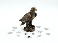 Detailed bronze eagle figurine statue isolated on white background surrounded by decorative star ornaments, suitable for home decor, collectibles, and design projects.