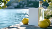 Glass bottle with fresh lemons on wooden pier against sparkling blue water background, natural sunlight creating bokeh effect and summer atmosphere.
