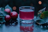 Cranberry juice in glass with fresh berries and frost-covered leaves on dark surface, suitable for beverage, food and drink, and wellness marketing.