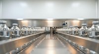 Modern commercial kitchen interior with stainless steel equipment and professional cooking stations for restaurant food service industry.