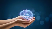 Human hands holding glowing digital brain with neural networks and connections on dark blue background representing artificial intelligence and technology.