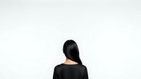 Woman with long black hair wearing black shirt viewed from behind against white background, isolated for design use.
