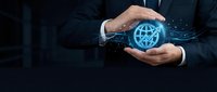 Professional businessman in dark suit protecting glowing blue global network icon with hands showing cybersecurity and data protection concept.