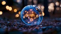 Glowing string lights reflected in glass sphere on dark ground with bokeh background creates magical evening atmosphere. For holiday and seasonal designs.