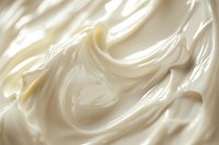 Creamy white swirls of soft whipped texture create luxurious waves and folds in smooth dairy dessert topping, close up macro photography with natural lighting.