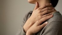 Person touching neck and shoulder area experiencing pain or discomfort, healthcare and wellness concept for medical treatment and therapy needs.