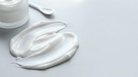 Luxurious white face cream with smooth creamy texture spread on clean surface, skincare moisturizer for anti-aging beauty routine and cosmetic applications.