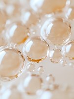 Macro photography of transparent water bubbles with soft beige background creating abstract pattern with light refraction and delicate bokeh effect.