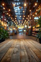 Empty wooden table in foreground with blurred marketplace hall background featuring warm string lights and bokeh effect, creating atmospheric retail environment.