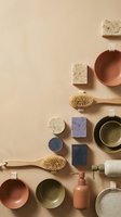 Flat lay arrangement of natural spa and skincare products including wooden brushes, ceramic bowls, handmade soaps, and bath accessories on neutral beige background for wellness and beauty marketing.