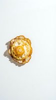 Golden fried egg with crispy edges isolated on white background, ready for culinary design projects and breakfast menu concepts.