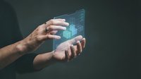 Hands holding futuristic holographic interface with glowing data visualization and digital charts for technology and innovation concepts.