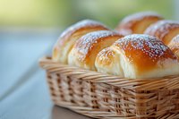 Fresh homemade sweet bread rolls dusted with powdered sugar arranged in woven basket, close-up view showing soft texture and golden brown crust.