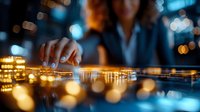 Female executive analyzing digital data visualization on interactive touchscreen display with glowing golden graphs and bokeh light effects in modern office setting.
