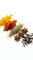 Colorful spice collection with turmeric, paprika, herbs, star anise and peppercorns scattered on white background for culinary and cooking projects.