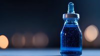 Glowing blue liquid in glass dropper bottle against dark background with soft bokeh lights, creating magical laboratory atmosphere for wellness concept.