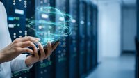 Businessman holding smartphone with glowing digital globe and data network visualization in server room environment for technology and global connectivity concepts.