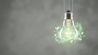 Glowing light bulb with green energy leaves and sparkles representing eco-friendly innovation and sustainable electricity solutions for environmental concepts.