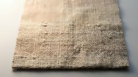 Natural burlap fabric texture with loose weave and frayed edges on white background, rustic material for crafting and home decor projects.