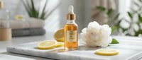 Golden essential oil or serum in dropper bottle with fresh lemon slices and white peony flower on marble surface for skincare and wellness product promotion.