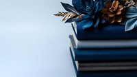 Elegant navy blue gift box with decorative bronze flowers and ribbon bow on light background for luxury packaging and special occasions.