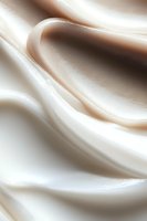 Smooth flowing abstract waves in cream and brown tones create elegant curves and soft gradients, suitable for luxury brand backgrounds and modern design projects.