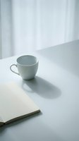 Empty gray ceramic mug on white table with open notebook, bright natural light from window, minimalist workspace setup for business, creative, and lifestyle design projects.