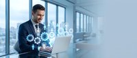 Professional businessman using laptop with digital gear icons in modern office space representing technology integration and business automation solutions.