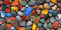 Colorful collection of polished gemstones and minerals creating abstract mosaic pattern, perfect for geology, jewelry design, or natural wellness backgrounds.