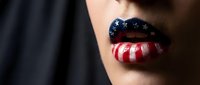 Woman with patriotic American flag makeup on lips featuring red white blue stripes and stars for Independence Day celebration and national pride.