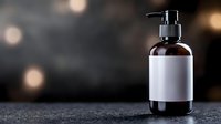 Amber glass pump bottle with blank white label on dark textured surface with warm bokeh lights background for cosmetic branding and product mockup designs.