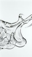 Clear liquid splashing and flowing dynamically against white background, capturing fluid motion and transparency for cosmetic, skincare, and beverage product advertising.