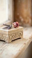 Vintage wooden jewelry box with ornate carvings topped with dried pink rose and lavender sprigs on rustic wood surface for romantic decor concepts.