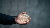 Hand holding glowing smart home icons on dark background. Technology concept for home automation, IoT, and connected living solutions.
