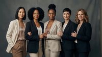 Group of five diverse women professionals standing together in business attire, representing teamwork, leadership and corporate success for business and corporate projects.