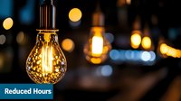 Glowing vintage filament light bulb with warm yellow bokeh background creates atmospheric mood lighting in dark interior space.