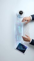 Businessman hands typing on keyboard with holographic data analytics dashboard charts and graphs projecting from tablet and coffee cup on white desk.