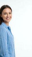 Young woman with long dark hair and Caucasian ethnicity wearing light blue denim shirt, smiling at camera against white background for corporate and lifestyle use.