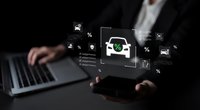 Professional businessman using laptop with digital eco-friendly house icon and sustainability symbols floating above hands on dark background.
