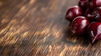 Fresh ripe dark red cherries on rustic wooden background with copy space. Natural lighting creates dramatic shadows, perfect for food photography and design.