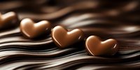 Three heart shaped milk chocolate candies on flowing dark chocolate waves background, romantic sweet food composition for Valentine's Day celebration.