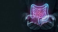 Glowing digestive system hologram floating above cupped hands showing intestinal tract anatomy for medical education and healthcare presentations.