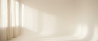 Minimalist empty room interior with natural sunlight streaming through window creating soft shadows on beige walls and wooden floor for product display.