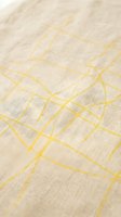 Cream linen fabric with yellow geometric grid pattern, close-up detail shot showcasing woven textile surface for interior design and home decor projects.