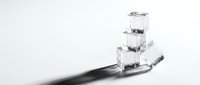 Stacked ice cubes on a black spoon against white background, isolated for design use on packaging, beverages, and culinary projects.